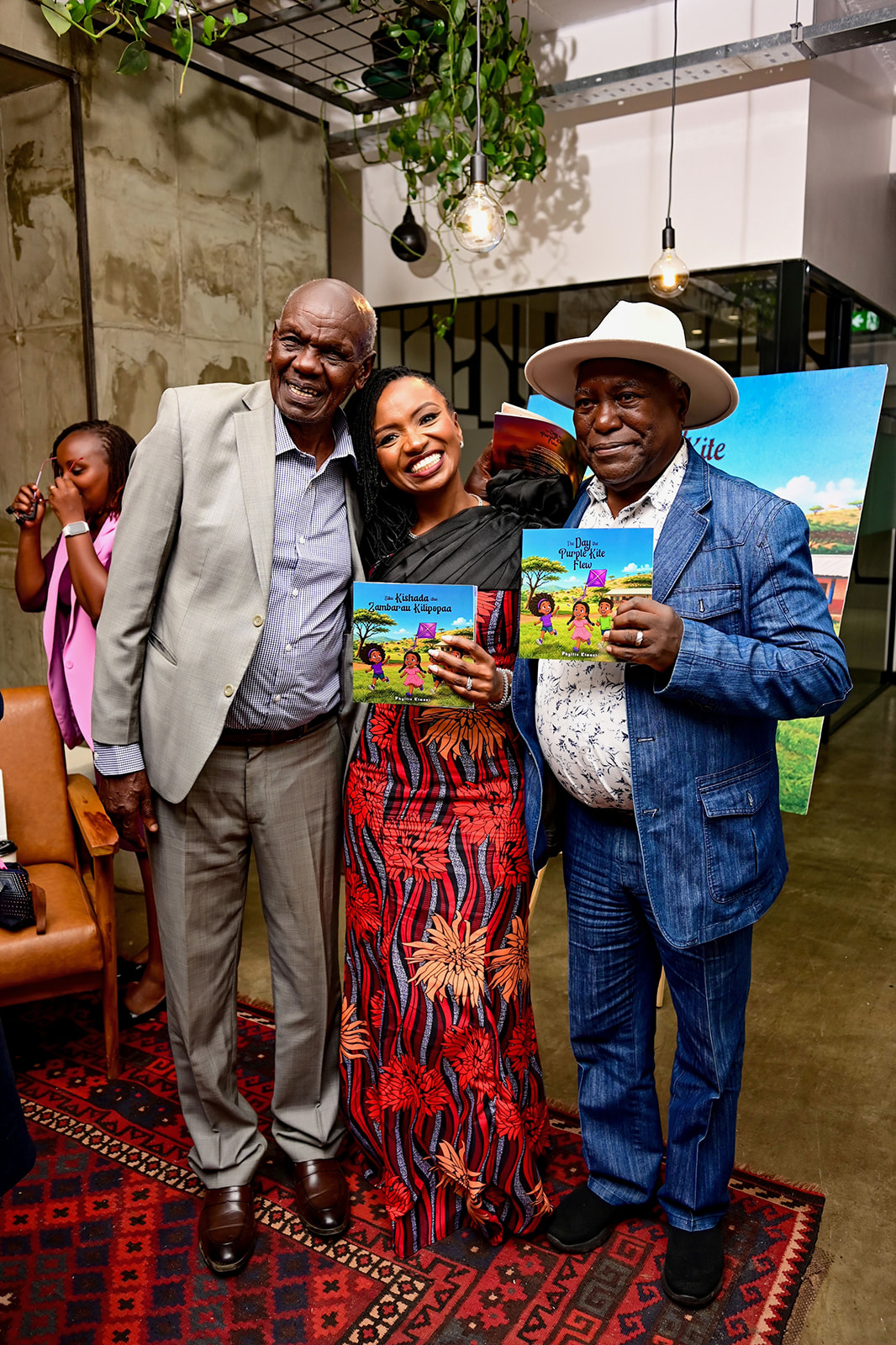 Dr Phyllis Kimani with guests holding copies of The Day the Purple Kite Flew and Kishada cha Zumbuaru Kilipopaa.