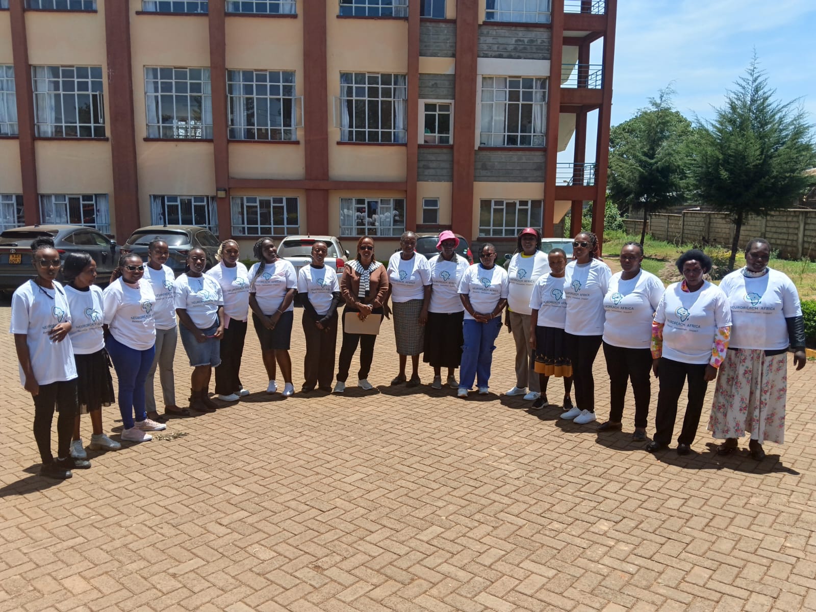 Newly trained Kabete Sub-County Epilepsy Champions in NeuroReach Africa T-shirts standing together outside a building