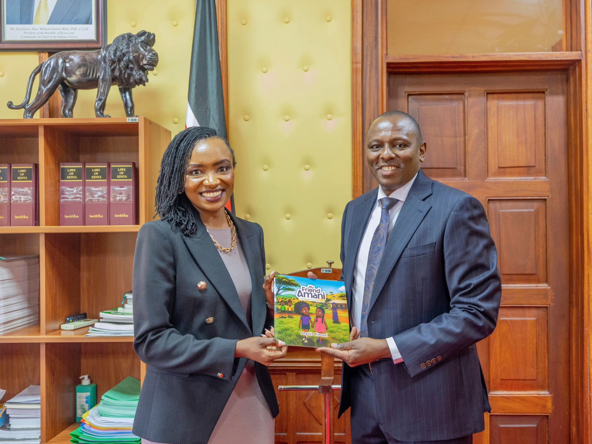 Dr Phyllis Kimani presents a copy of My Friend Amani to Hon. Kimani Ichung'wah during their meeting.