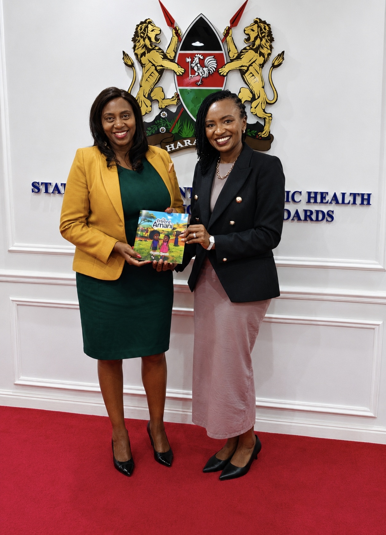 Dr Phyllis Kimani presents a copy of My Friend Amani to PS Mary Muthoni at the Ministry of Health.