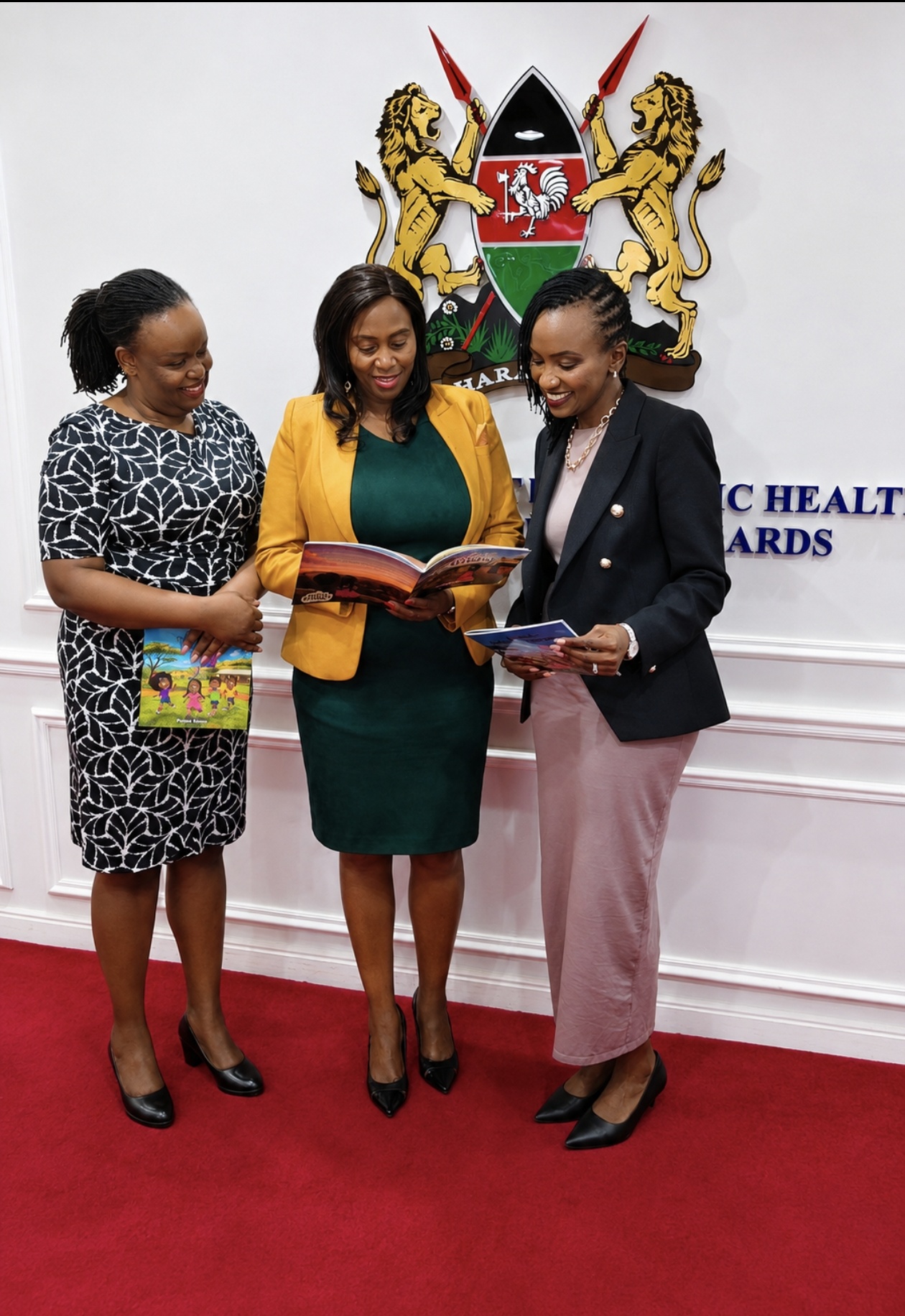 Dr Phyllis Kimani with PS Mary Muthoni and Dr Wairimu Mbogo looking at NeuroReach Friends Series books at the Ministry of Health.